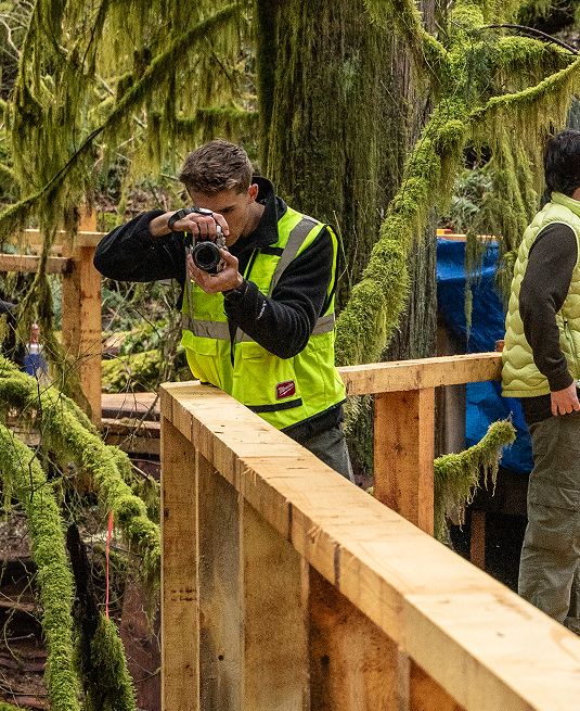 A photographer at work among the construction crew on the walkway