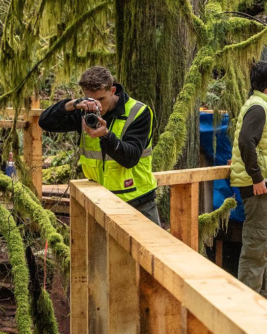 A photographer at work among the construction crew on the walkway