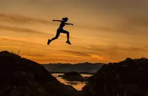 Person doing a high mobility jump against a stunning sunset backdrop