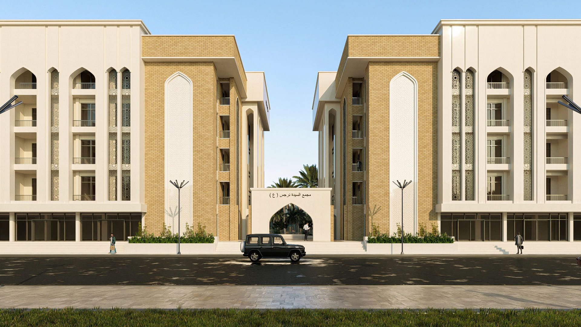 المجمّع السكني نهاراً: عمارتان بالطابوق الأصفر والحجر الأبيض فوق محالّ تجارية، يتوسّطهما مدخل مقوّس