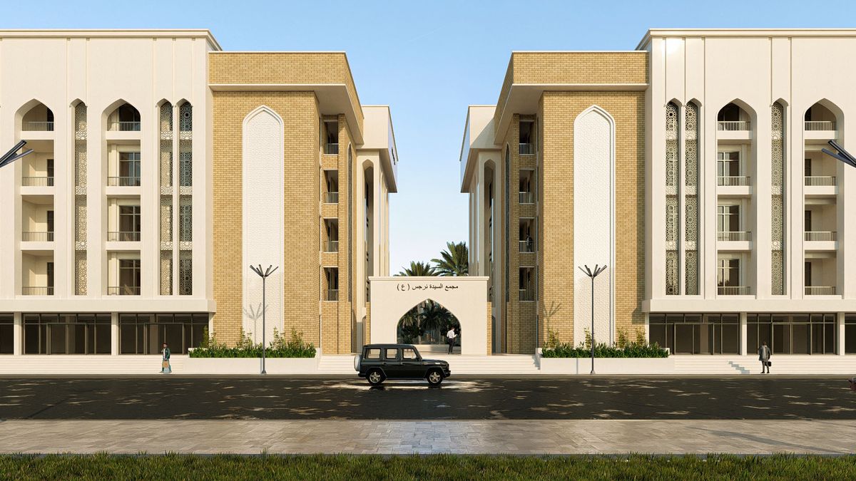 المجمّع السكني نهاراً: عمارتان بالطابوق الأصفر والحجر الأبيض فوق محالّ تجارية، يتوسّطهما مدخل مقوّس