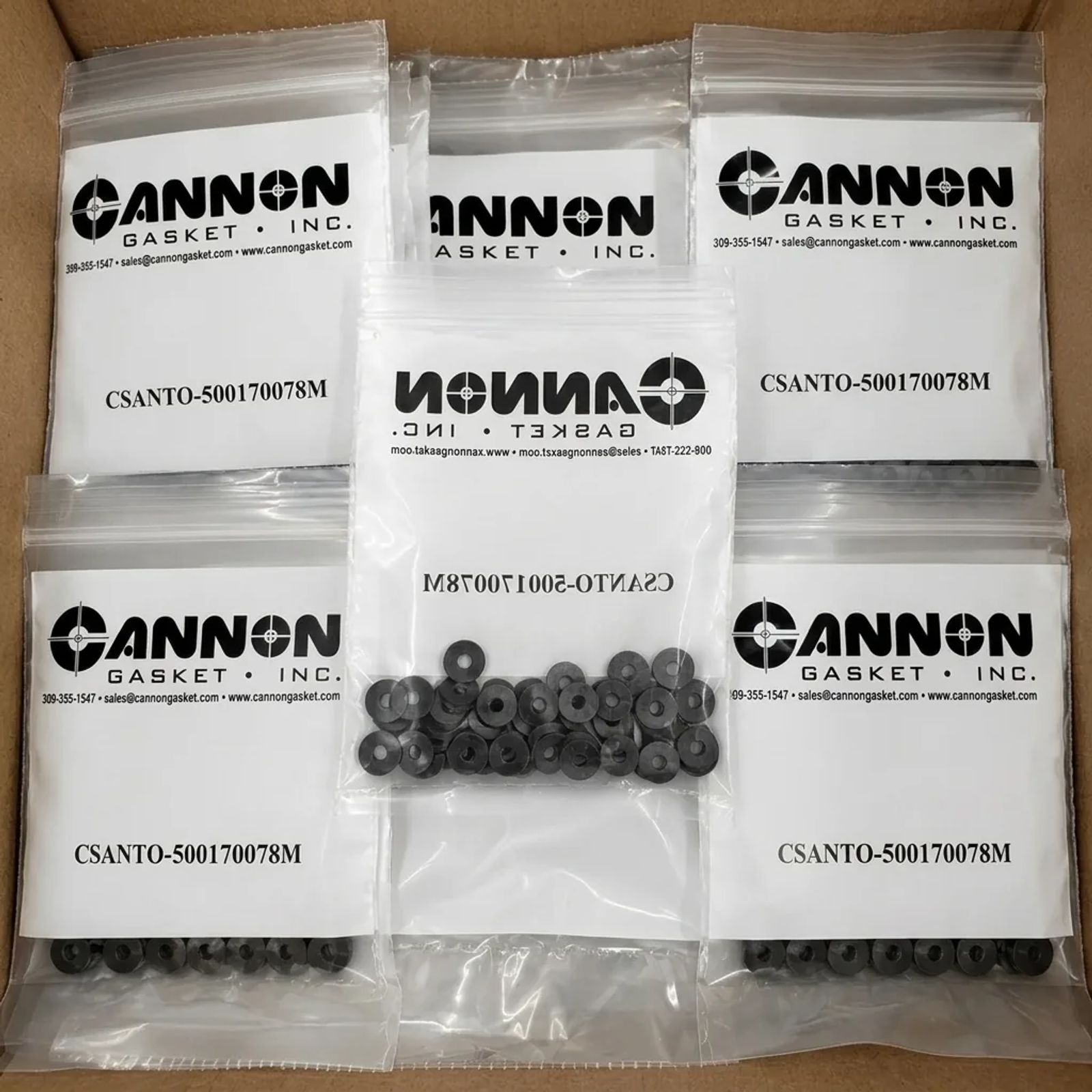 Clear labeled Cannon Gasket poly bags of black rubber washers kitted and tagged in a shipping box.