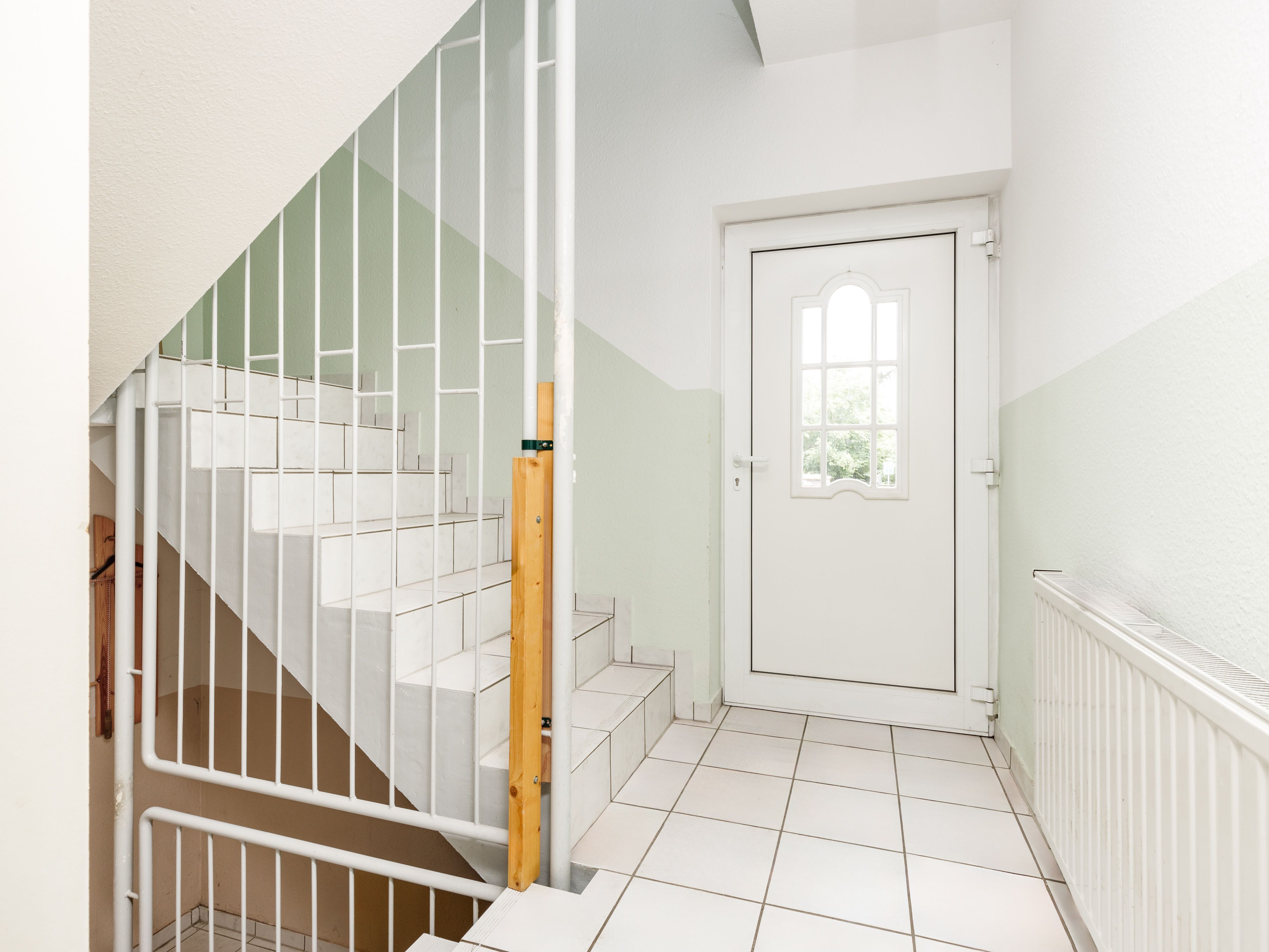Gefliestes Treppenhaus mit Zugang zum Obergeschoss