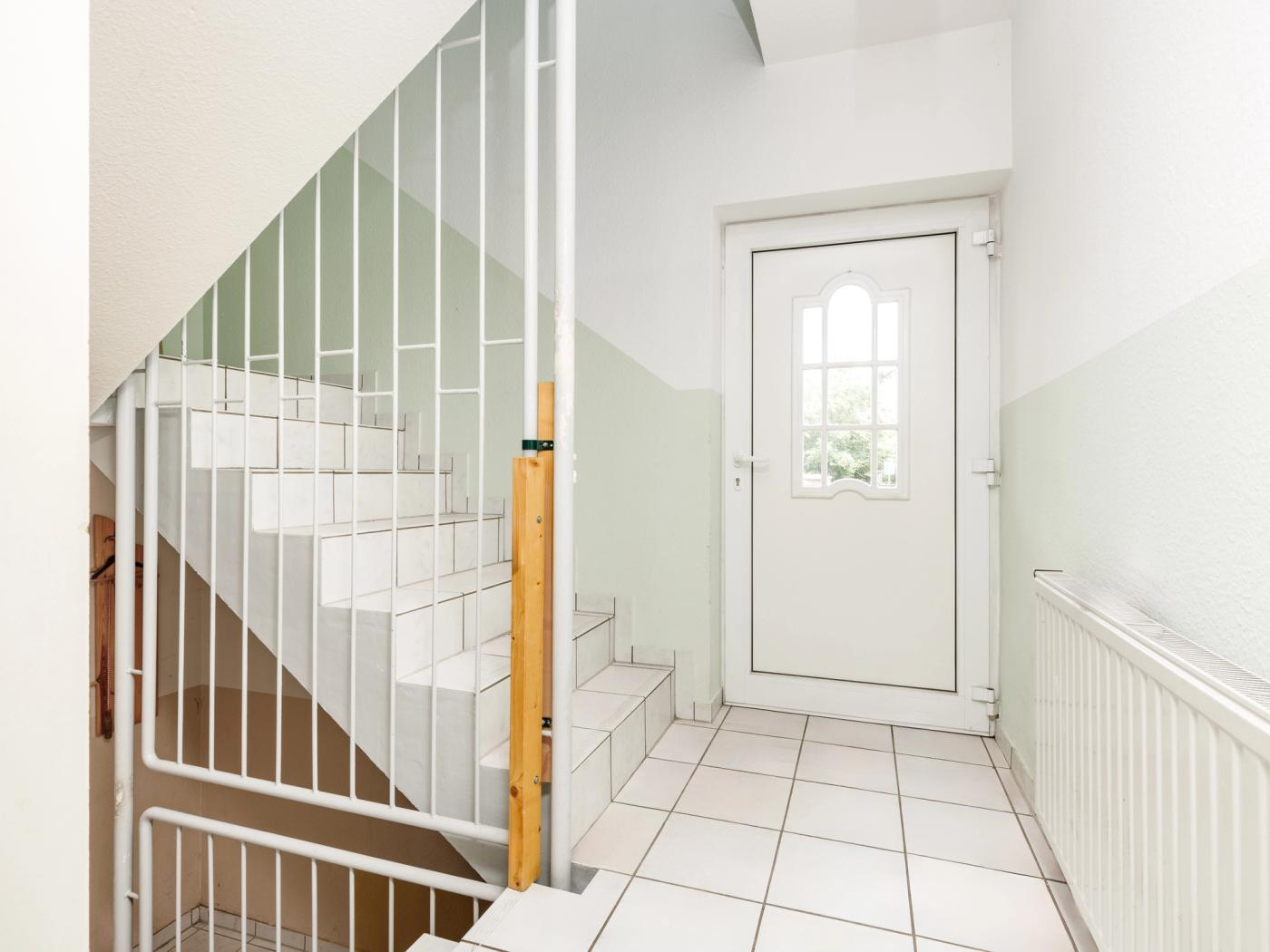 Gefliestes Treppenhaus mit Zugang zum Obergeschoss Gefliestes Treppenhaus mit Zugang zum Obergeschoss