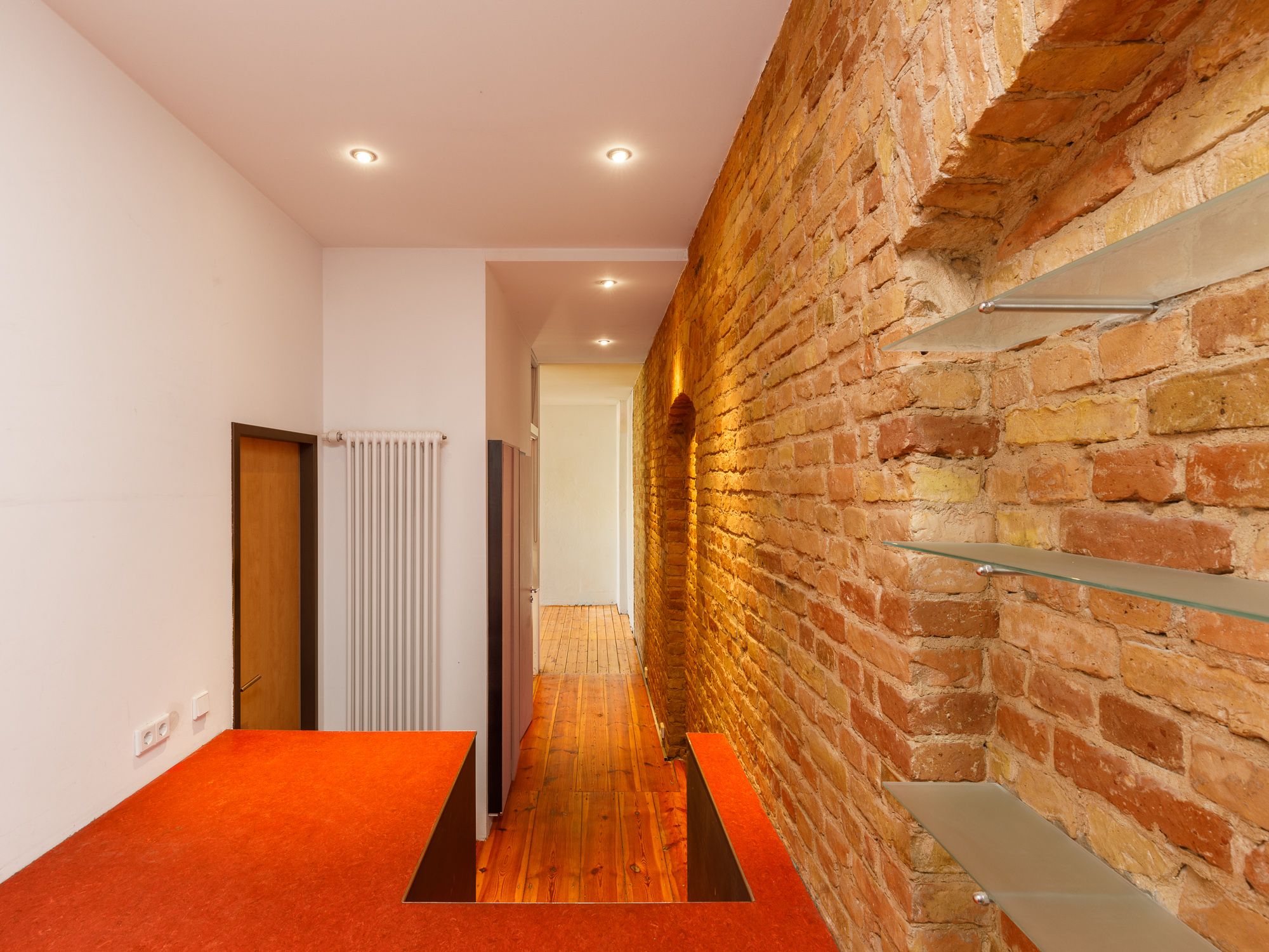 Flur mit freigelegter Backsteinwand 