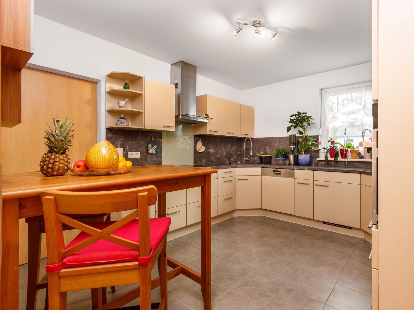 Küchenbereich mit moderner Einbauküche und Hauswirtschaftsraum Küchenbereich mit moderner Einbauküche und Hauswirtschaftsraum