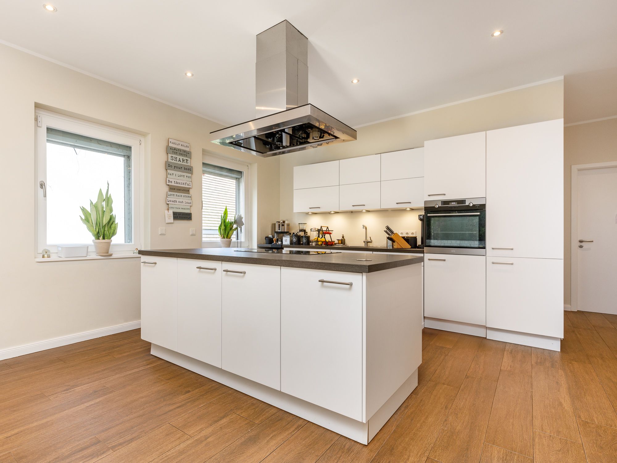 Moderne Einbauküche mit Markengeräten und Kochinsel