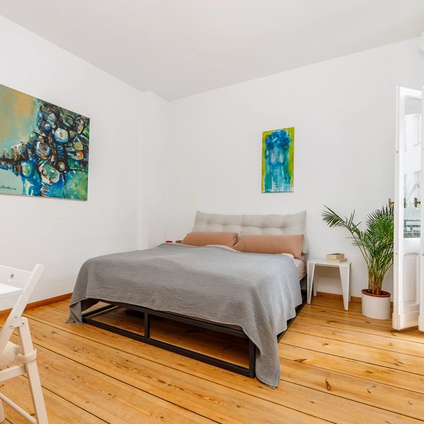 Schlafzimmer Dielenboden Doppelbett Kunstwerke