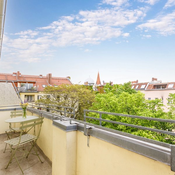 Balcony table chairs trees sky