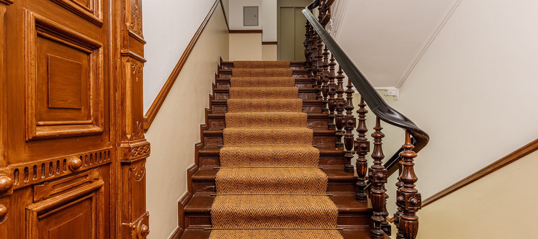 Schönes Treppenhaus mit Sisal-Teppich und historischen Holztüren Schönes Treppenhaus mit Sisal-Teppich und historischen Holztüren