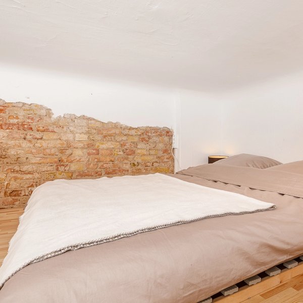 Schlafbereich Dachschräge Backsteinwand Doppelbett