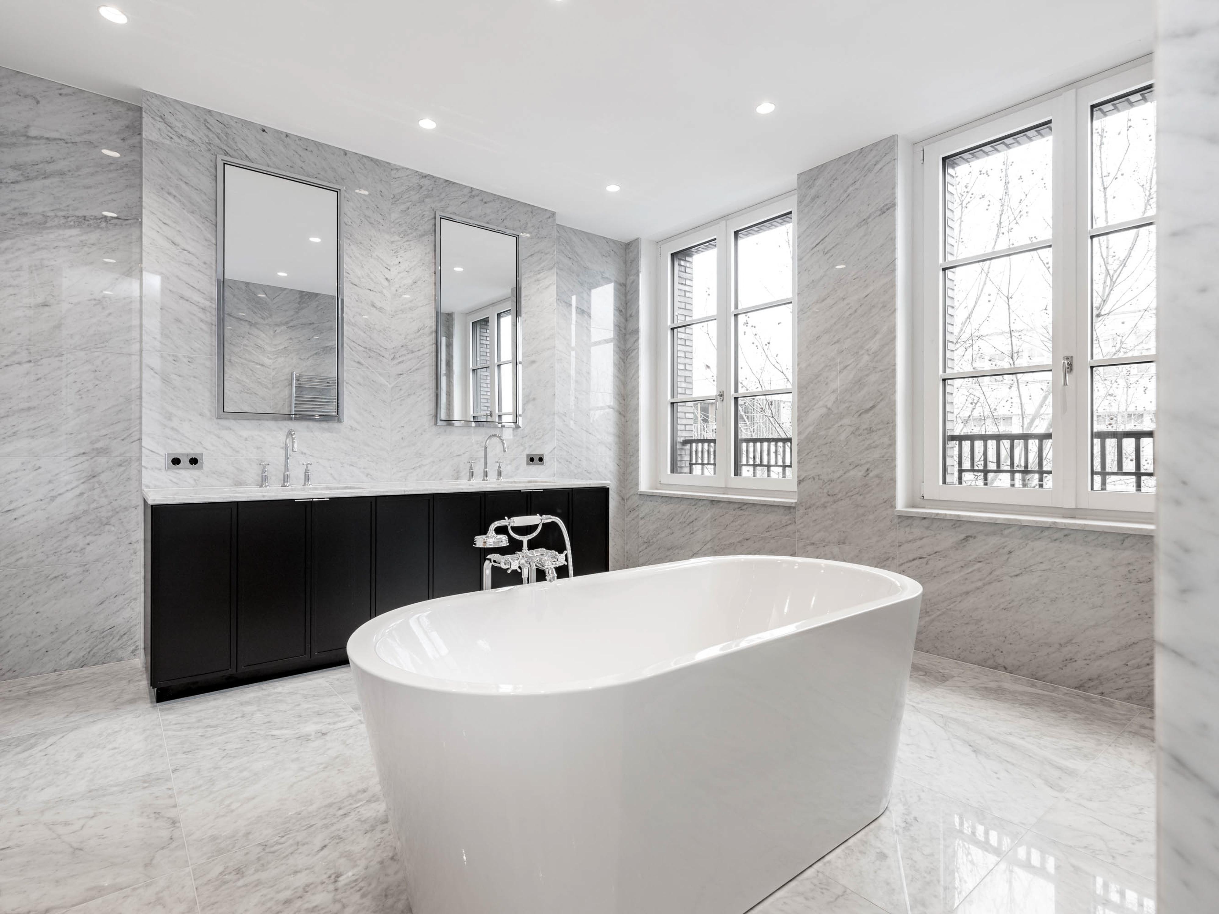 Luxuriöses Badezimmer mit freistehender Badewanne und Marmorfliesen