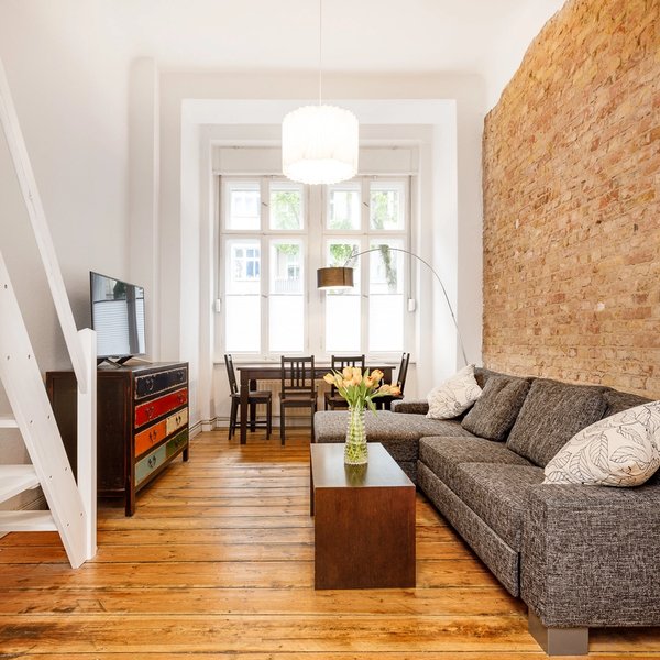 Wohnbereich Backsteinwand Dielenboden Fensterfront