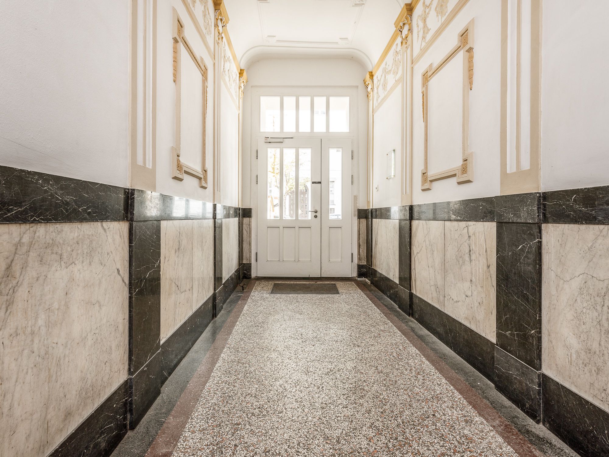Entrance area of the building with golden stucco features 
