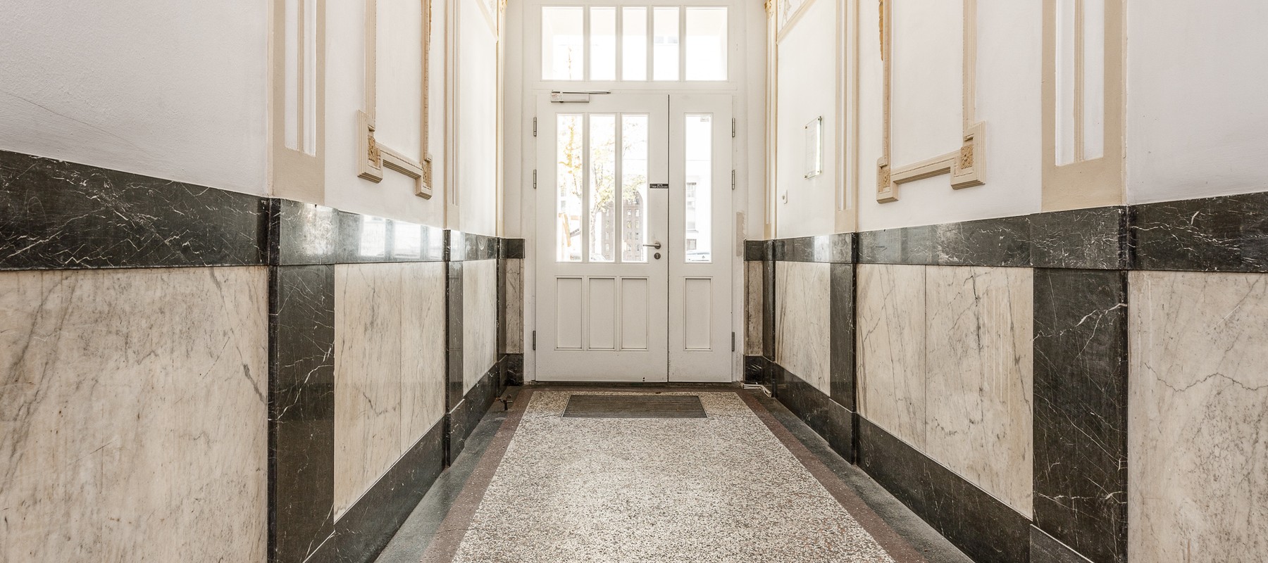 Entrance area of the building with golden stucco features Entrance area of the building with golden stucco features