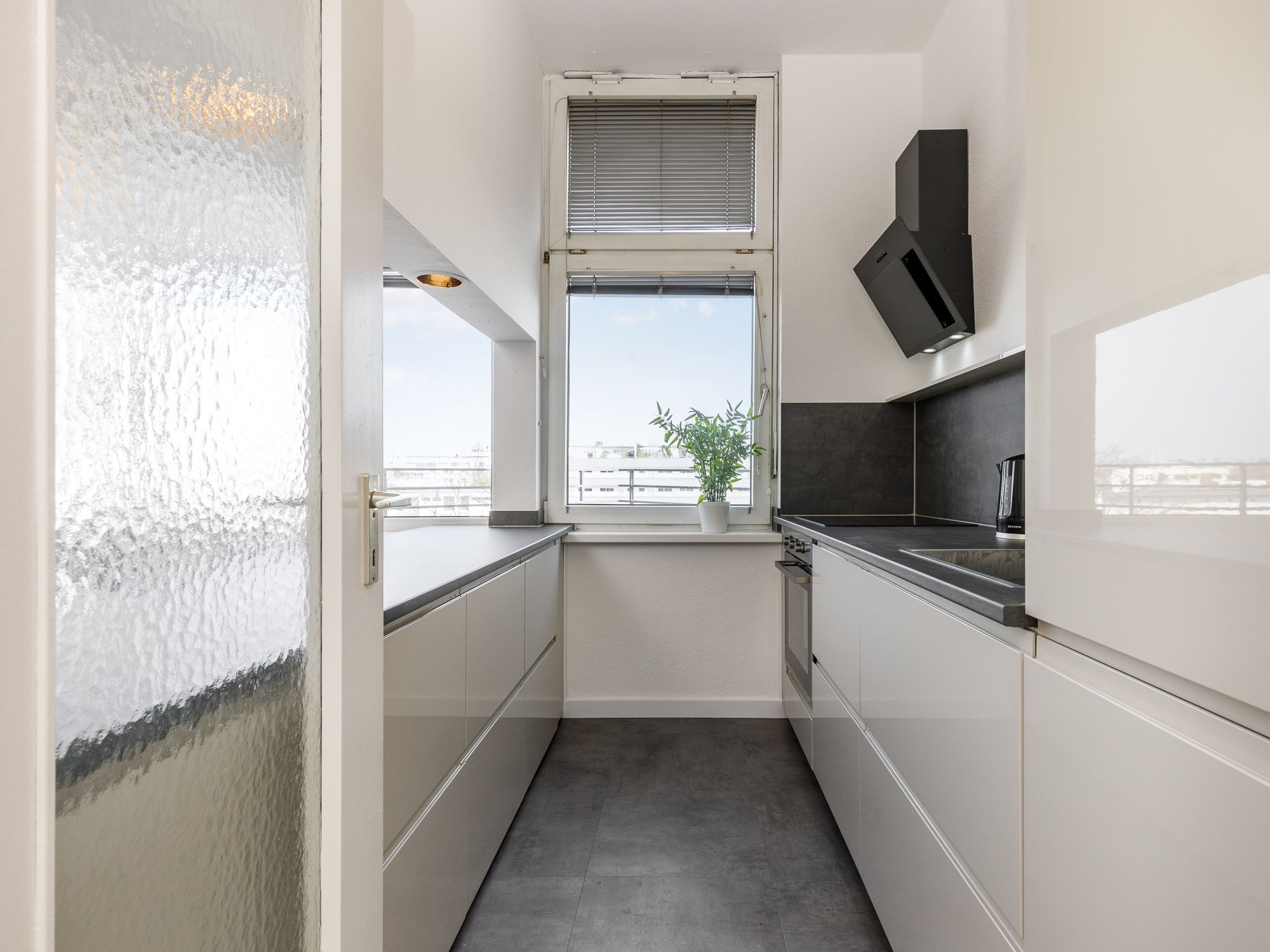 Moderne Einbauküche mit Elektrogeräten und Theke  