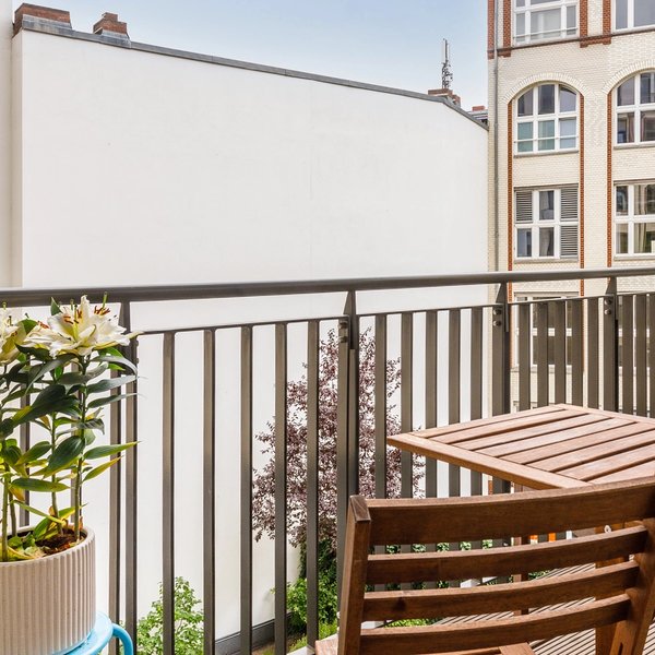 Balkon Holztisch Geländer Innenhofblick