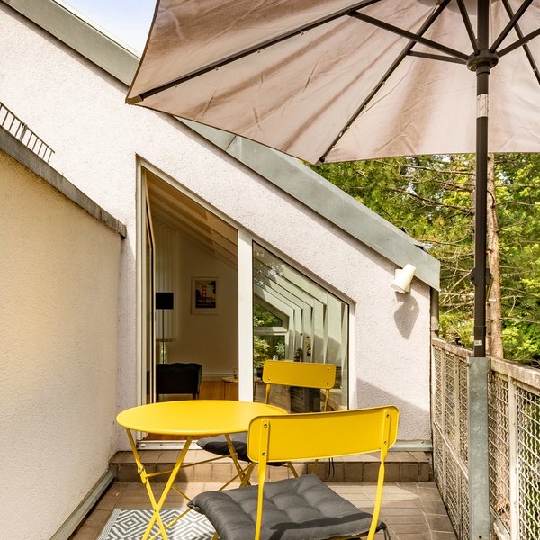 Balkon Tisch Stühle Sonnenschirm Bäume
