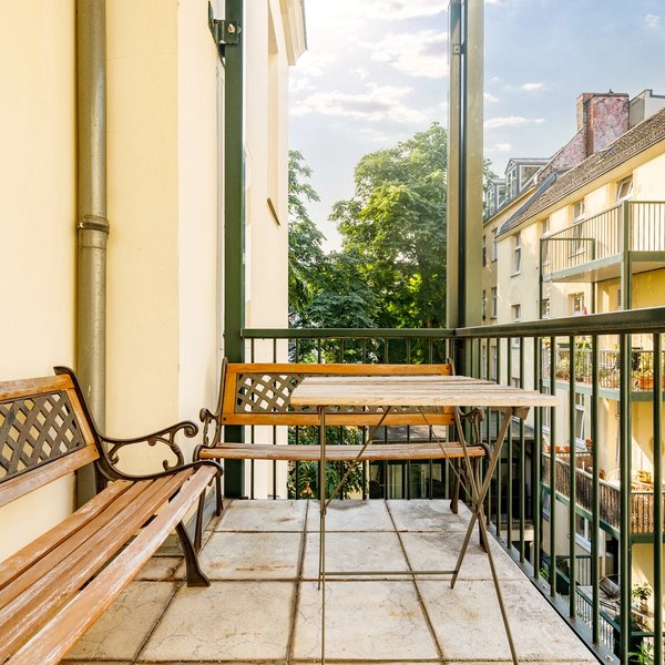 Balkon Innenhofblick Holzbänke Nachbarfassade