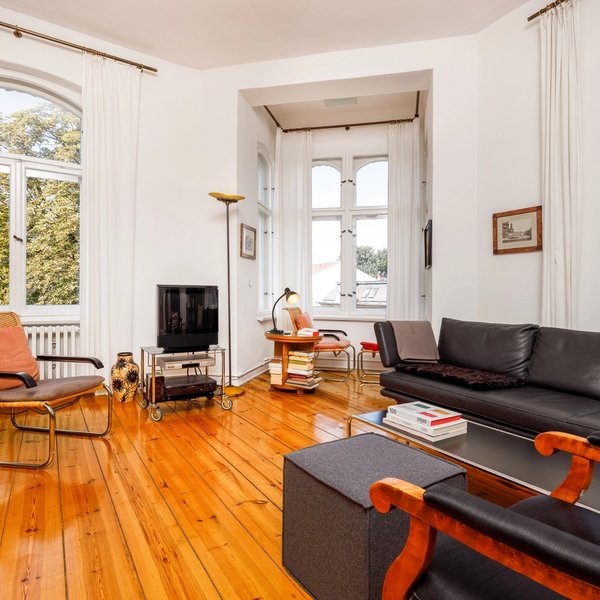 Wohnzimmer Dielenboden Sofa Sessel hohe Fenster