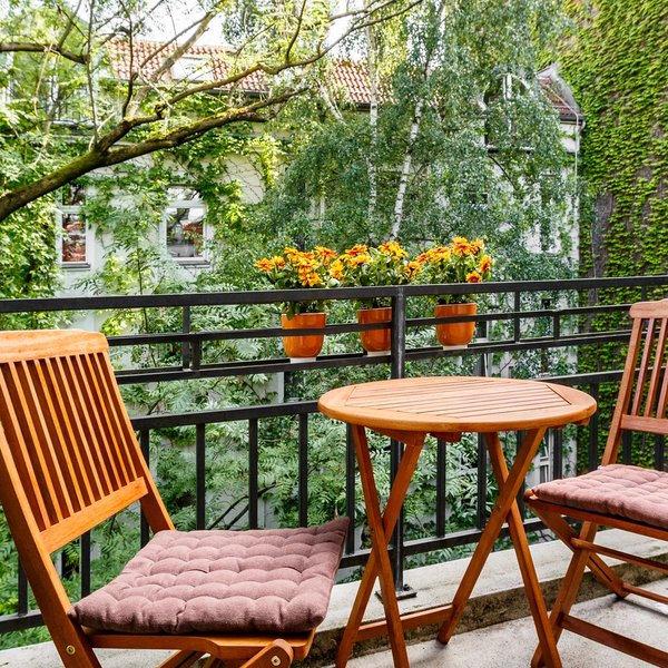 Balkon Tisch Stühle Geländer Pflanzen Innenhof Bäume