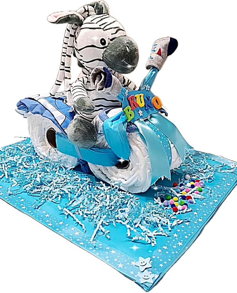 Triciclo de pañales personalizado con peluche de cebra. Detalle lateral con base azul decorada y nombre del bebé en letras de colores.