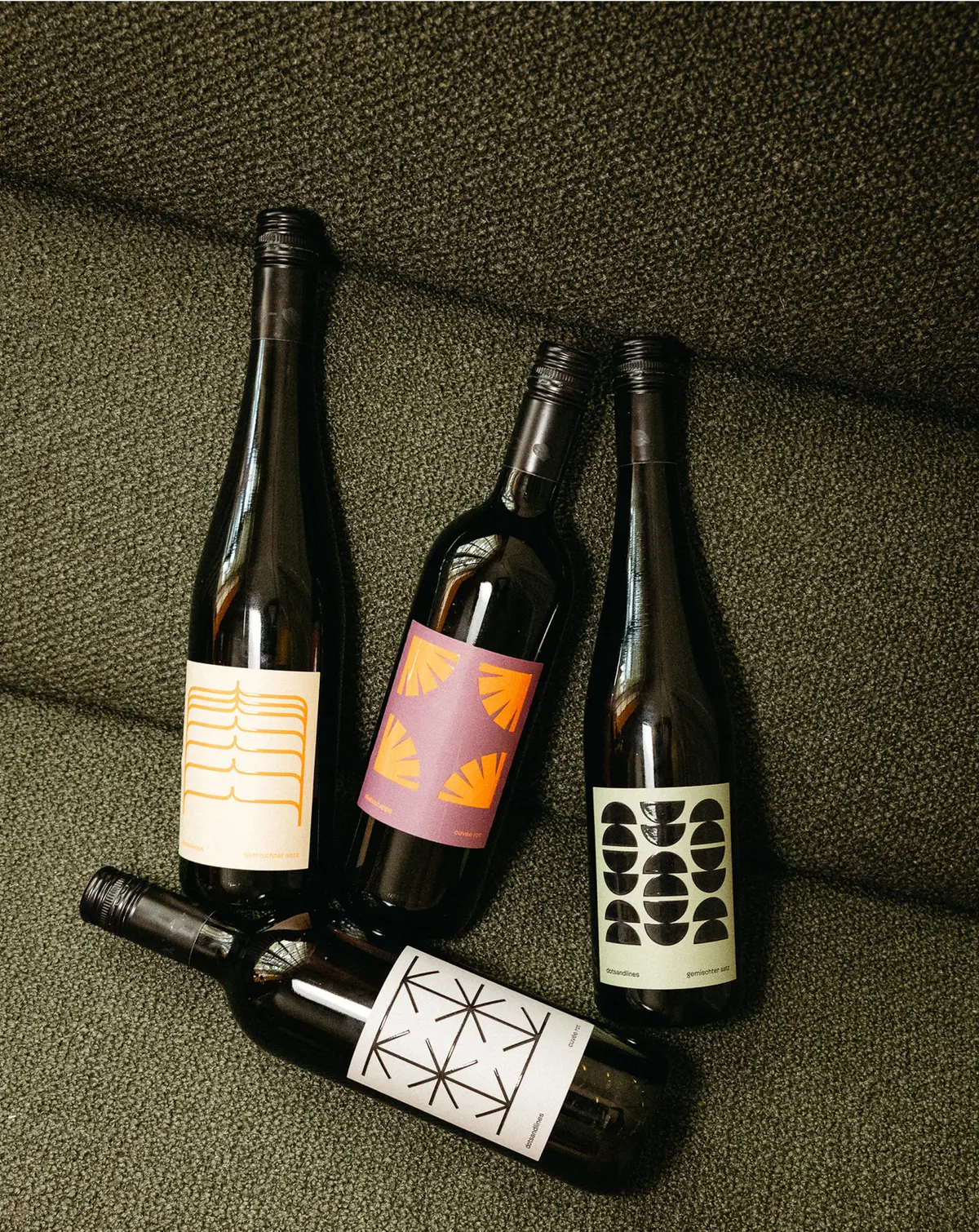 Four bottles with different labels on a couch