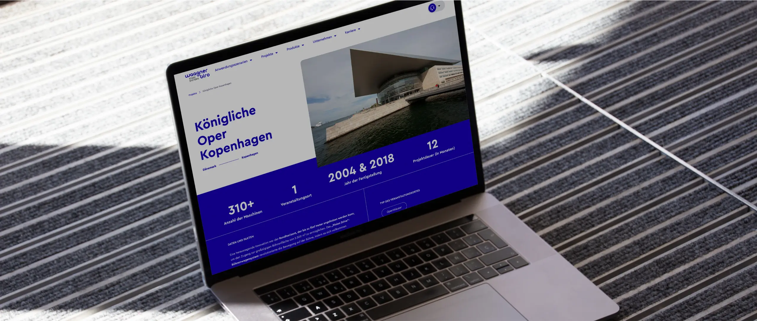 Laptop zeigt Website auf Gebäudedach