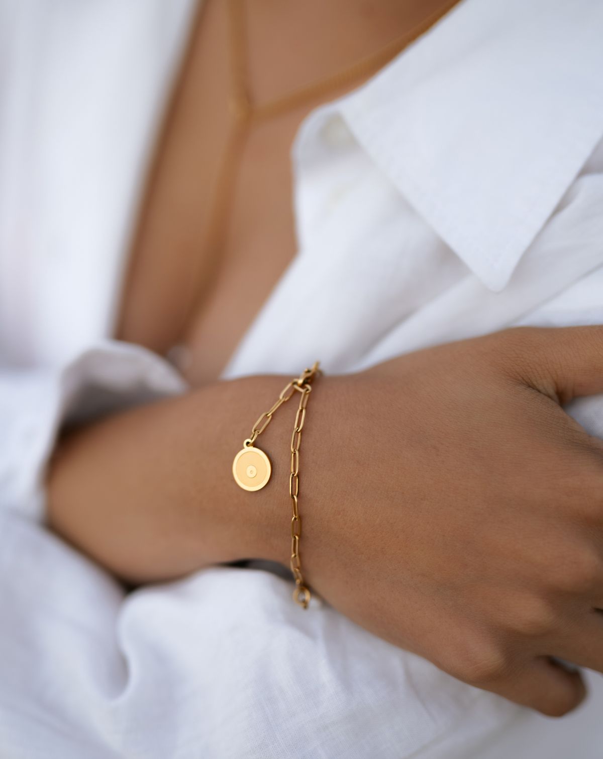 Goldschmuck glitzert, Frau steht am Felsenstrand