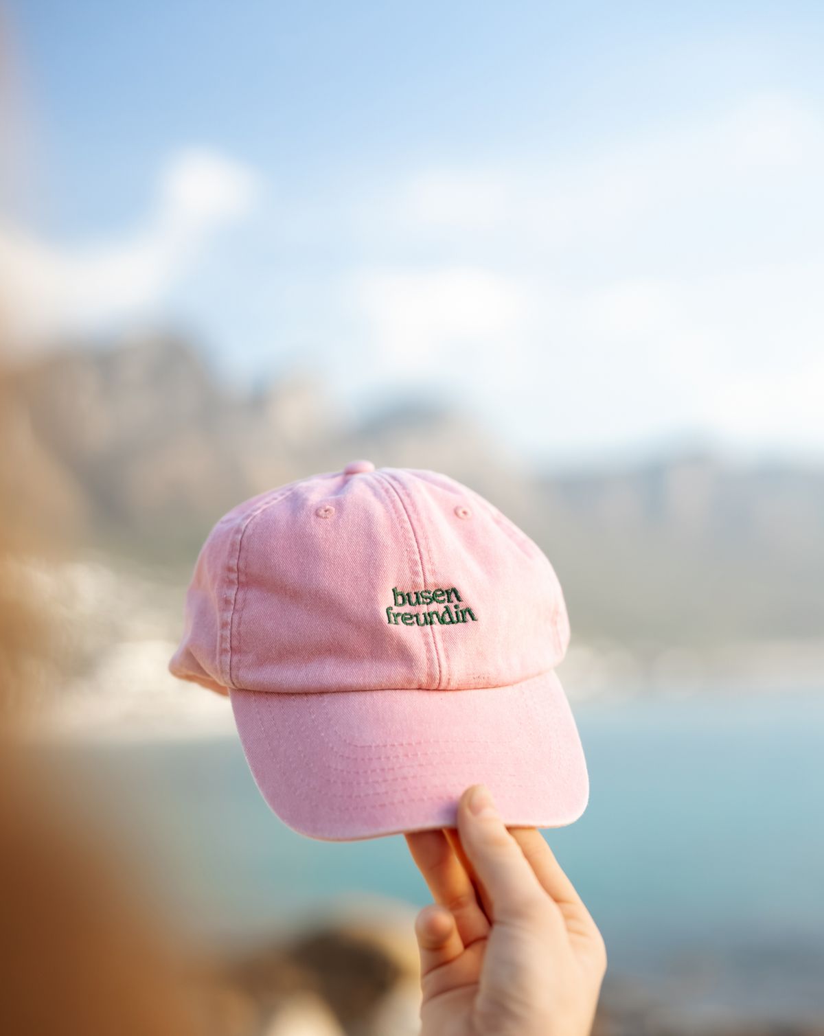 Pinke Cap vor Meer und Bergen Kapstadts