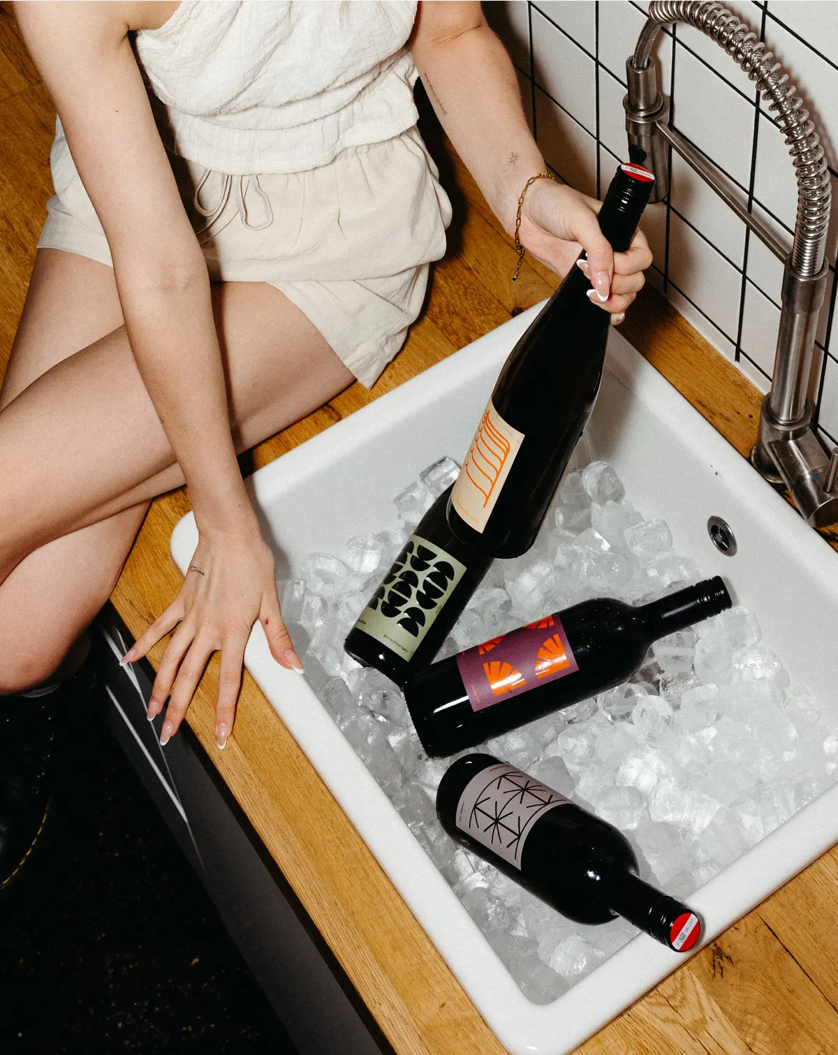 Hand reaching for wine bottle in ice bucket