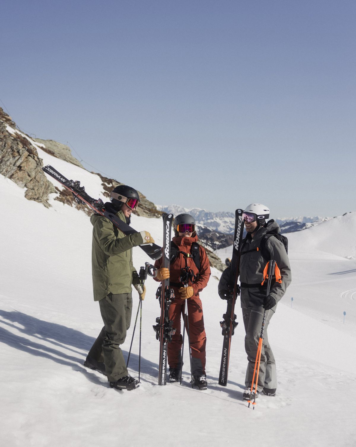 Skigruppe steht am Gipfel mit Ausrüstung im Schnee
