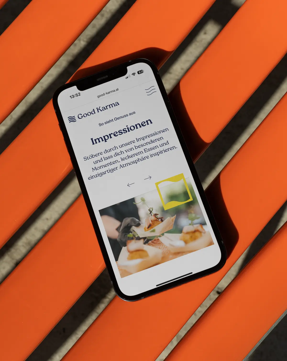 Smartphone mit Website auf orangener Bank