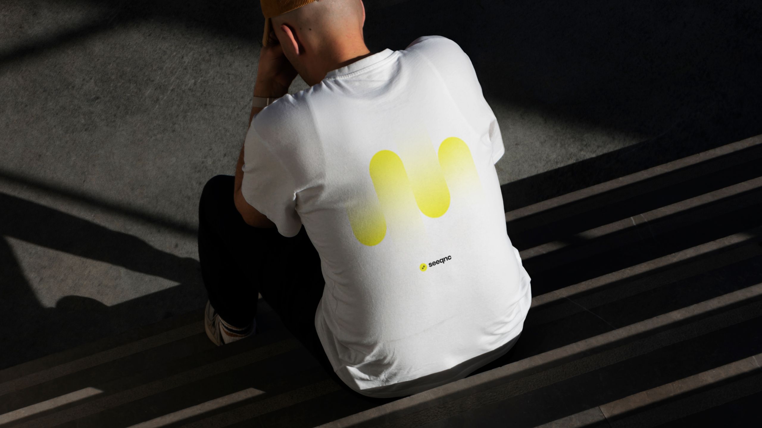 Rückseite eines T-Shirts mit gelbem Seeqnc-Logo bedruckt