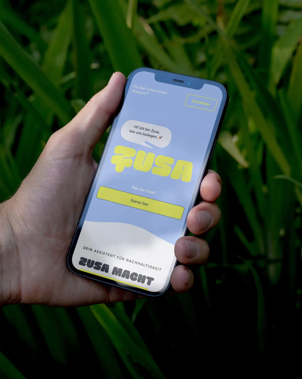 Hand mit Smartphone zeigt App in grüner Umgebung
