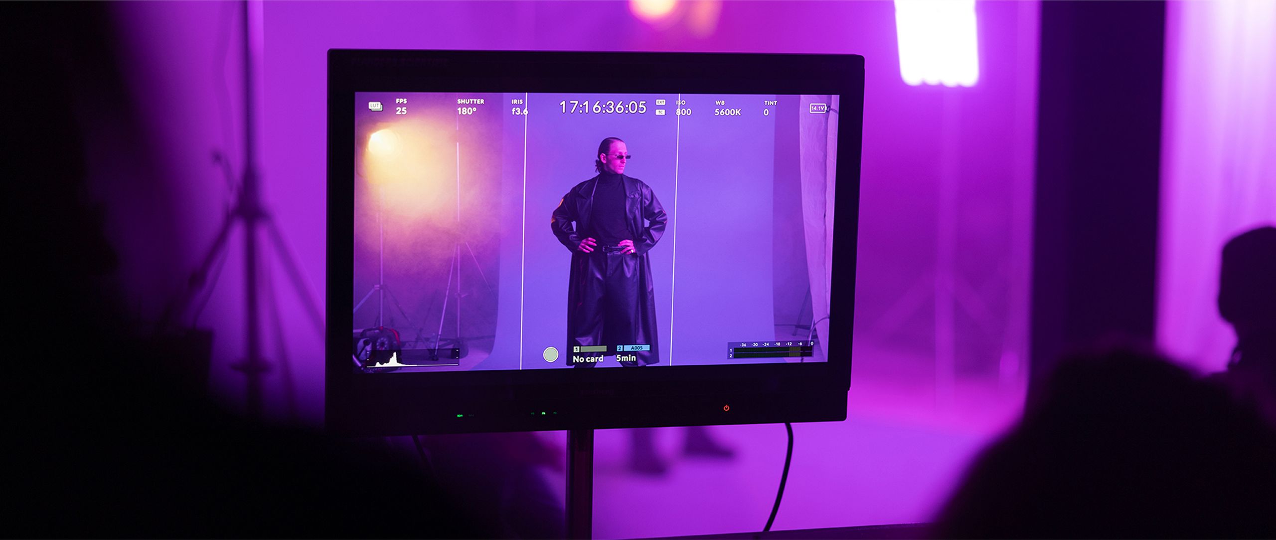 Model steht auf Bühne in violettem Licht