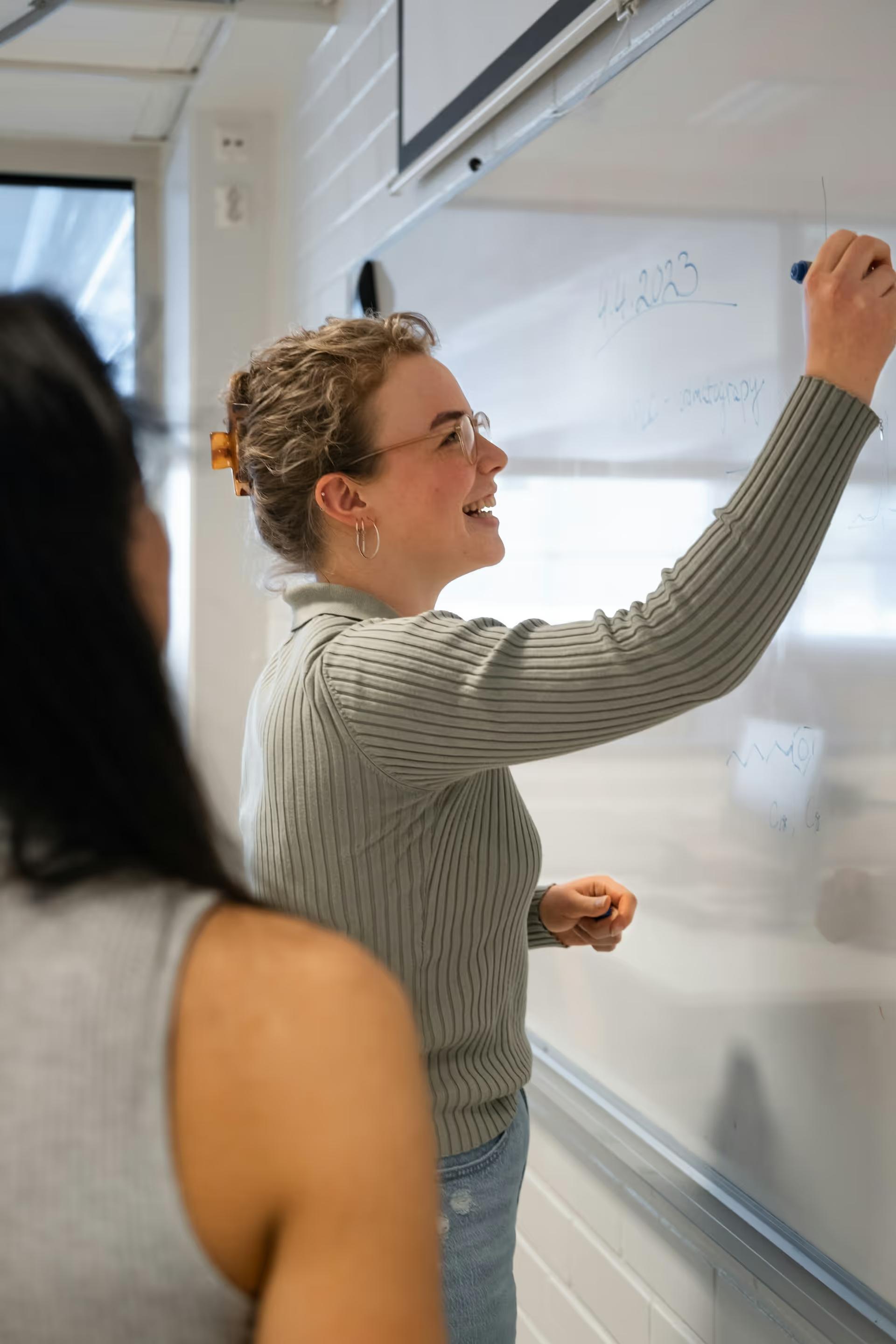 Woman writing on a whiteboard during a group session