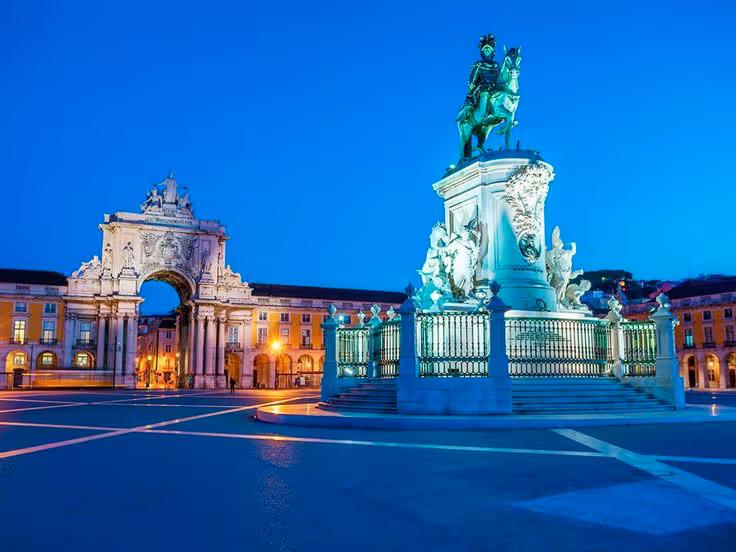 Praça do Comércio with its equestrian statue and triumphal arch at dusk