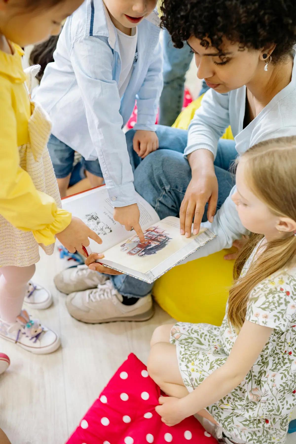 Educator reading a book with young children on the floor