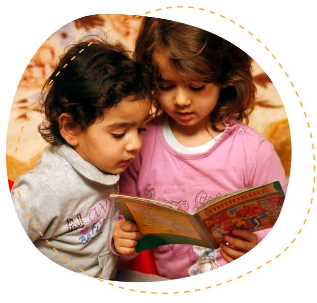 Two young girls reading a picture book together