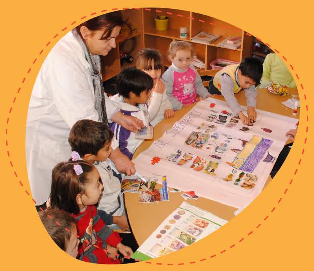 Educator and young children looking at pictures laid out on a table