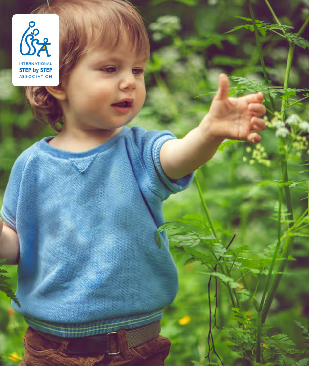 Toddler reaching towards plants outdoors