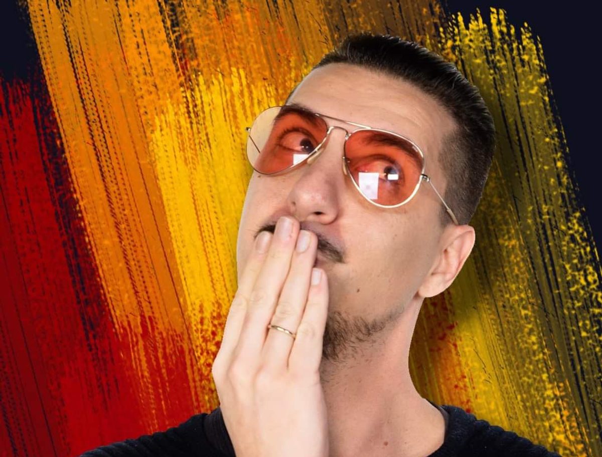 Ritratto di Raffaele Sogni con occhiali arancioni su sfondo colorato.