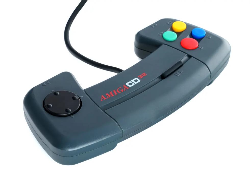 Controller originale CD32, con pad direzionale circolare a sinistra e quattro pulsanti azione colorati sulla destra.