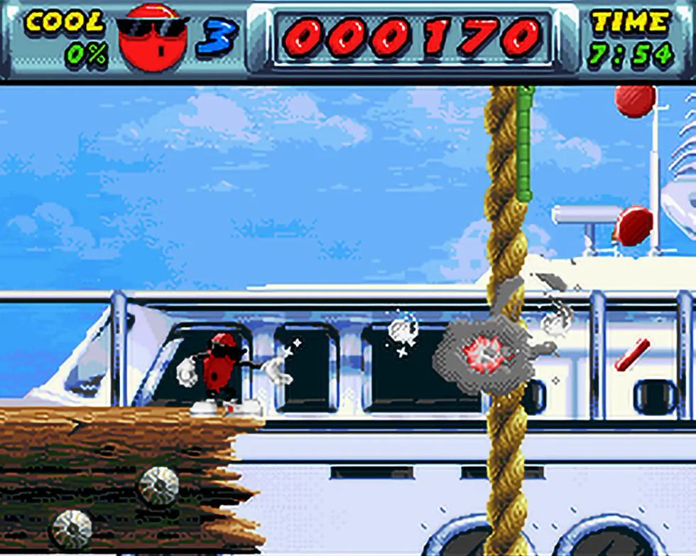 Cool Spot attacca i nemici lanciando bolle in un livello platform su SNES.