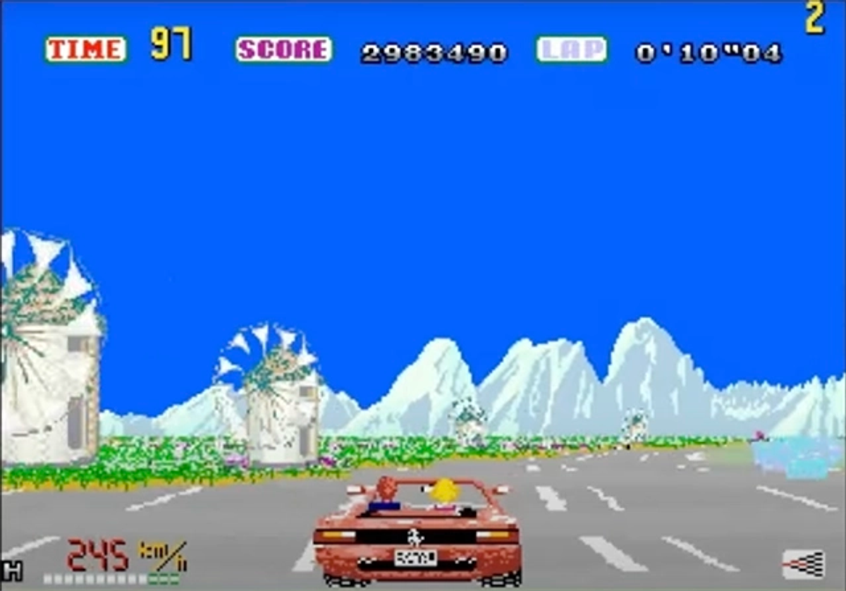 Schermata di gioco di Out Run con Ferrari rossa su strada costiera.