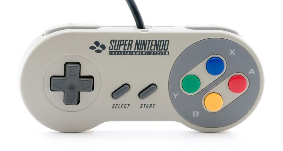 Controller Super Nintendo con croce direzionale, quattro pulsanti frontali colorati e tasti Select e Start.