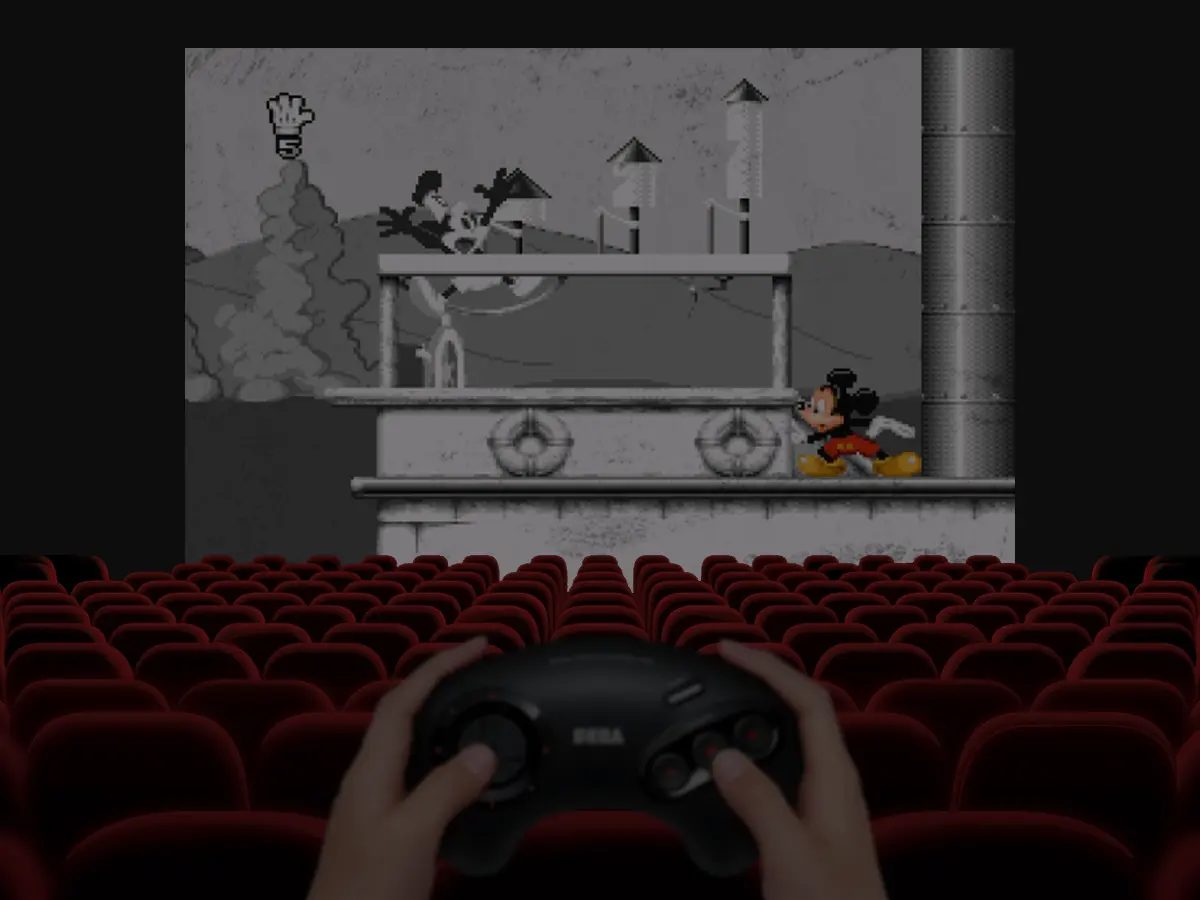 Un giocatore impugna un controller Sega davanti a uno schermo cinematografico con Mickey Mania