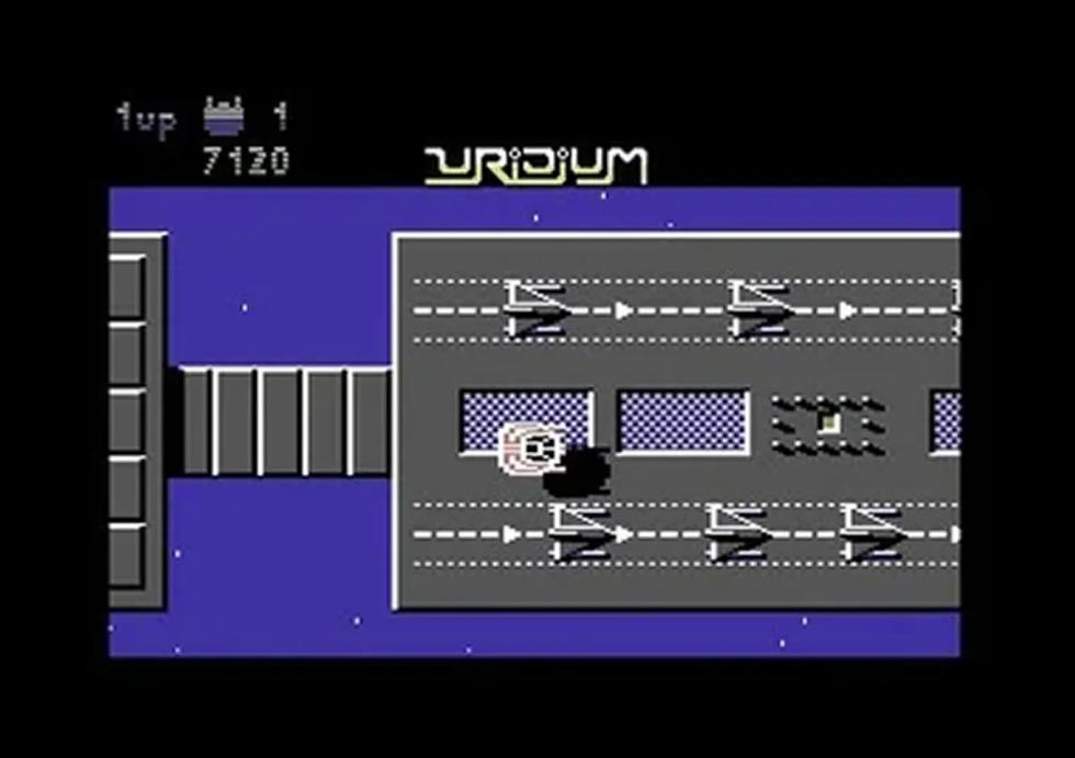 Schermata di Uridium per Commodore 64 con un'astronave che sorvola la superficie di una grande nave nemica.
