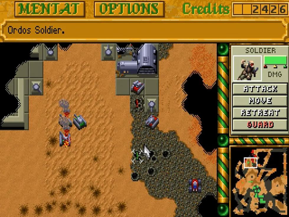 Schermata di Dune II con unità militari, strutture e interfaccia strategica sul deserto di Arrakis.